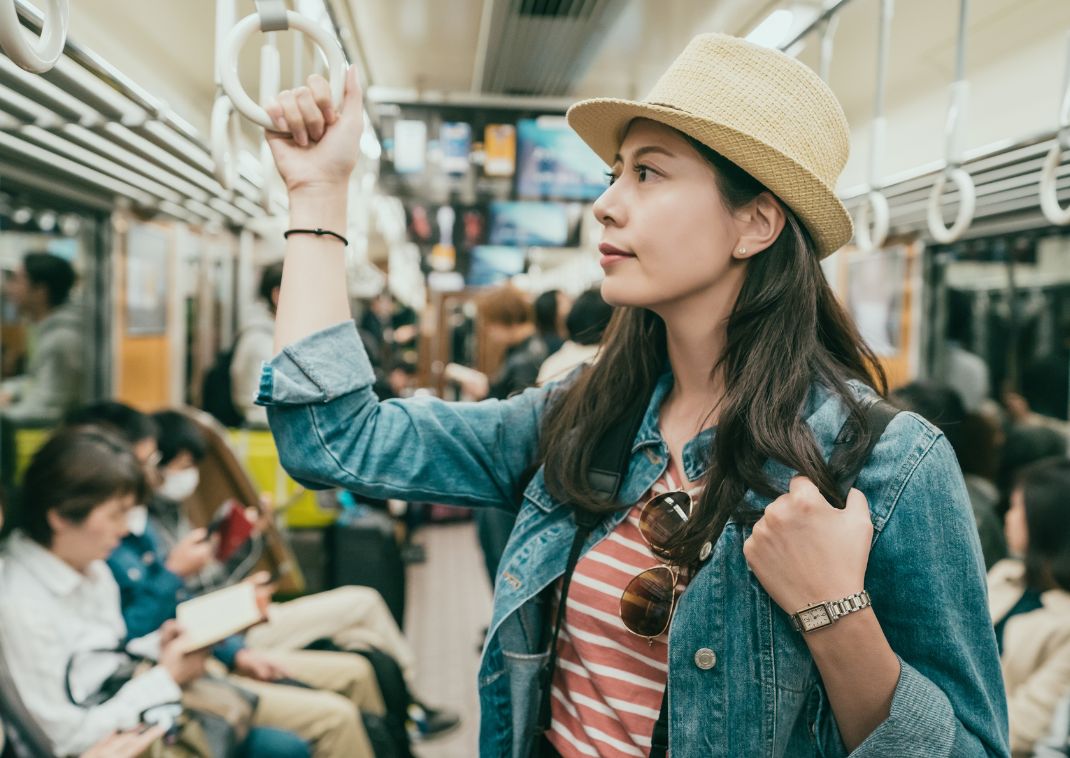 Jeune femme voyageuse tenant une poignée de main dans une rame de métro au Japon