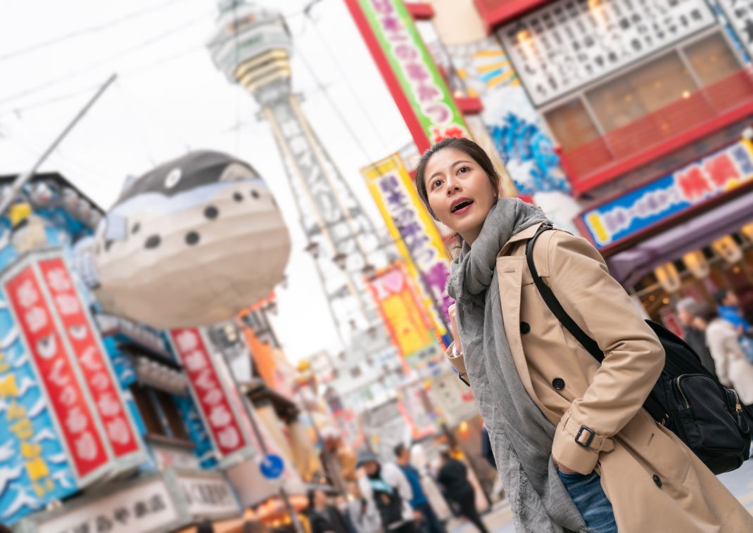 Jeune femme explorant le quartier Shinsekai d'Osaka