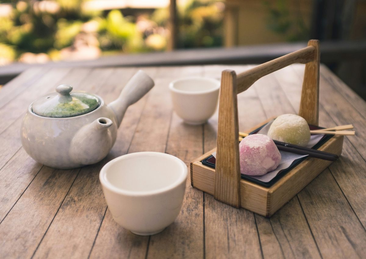 Plateau avec théière, tasse et wagashi dans un jardin de thé