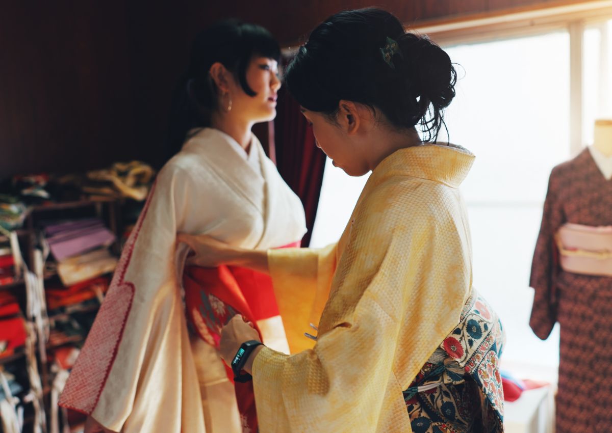 Femme aidant une autre femme à enfiler un kimono