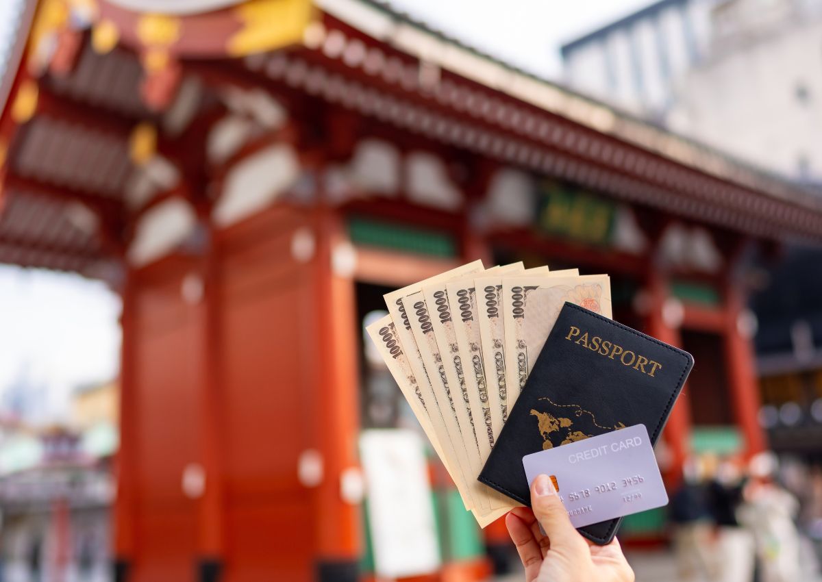 Main tenant des billets, un passeport et une carte de transport devant le temple Sensoji à Tokyo, Japon