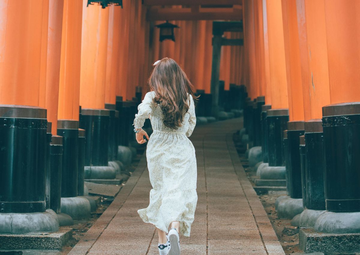 Jeune femme courant dans le sanctuaire Fushimi Inari, Kyoto, Japon