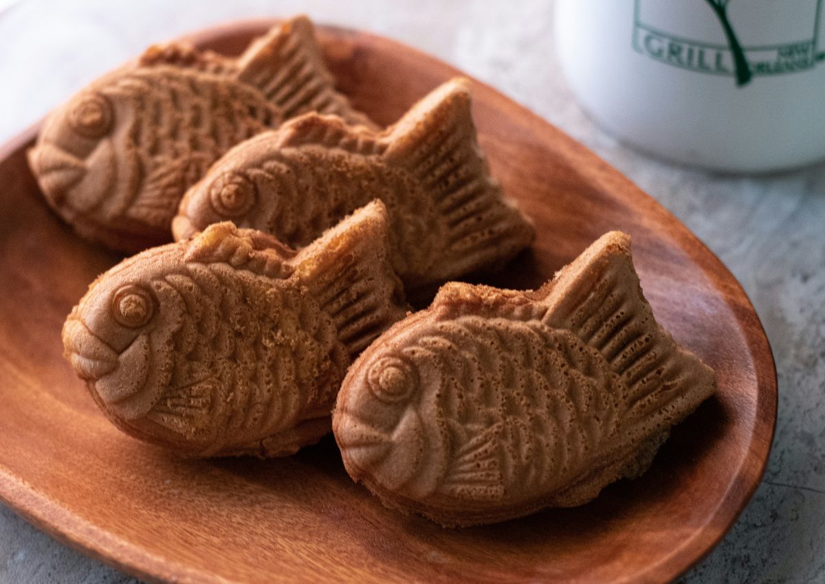 Quatre taiyaki disposés sur un plat en bois