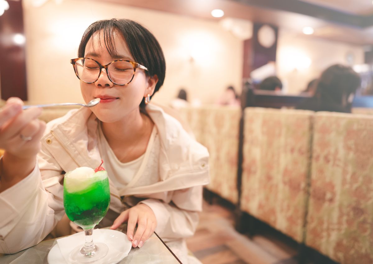 Jeune femme dégustant un cream soda dans un kissaten japonais
