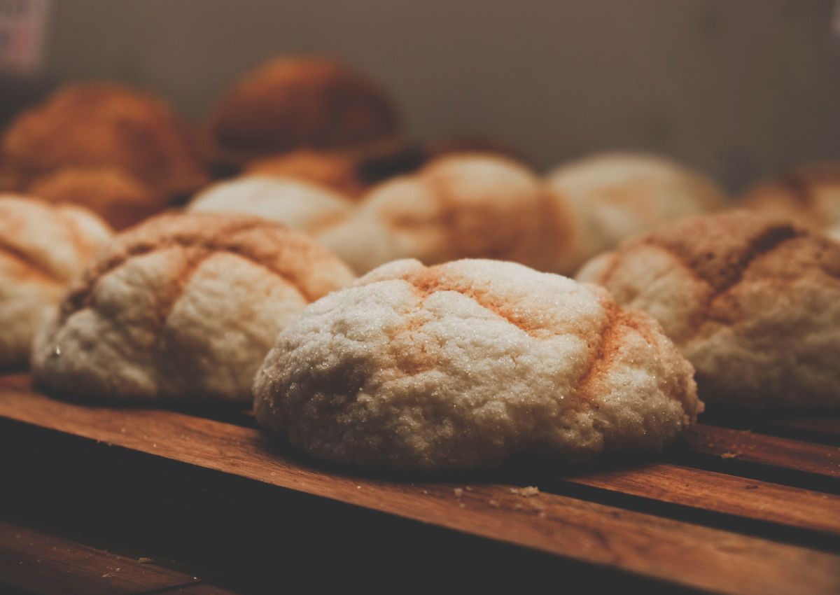 Fournée de melon pan exposés sur un support de boulangerie en bois