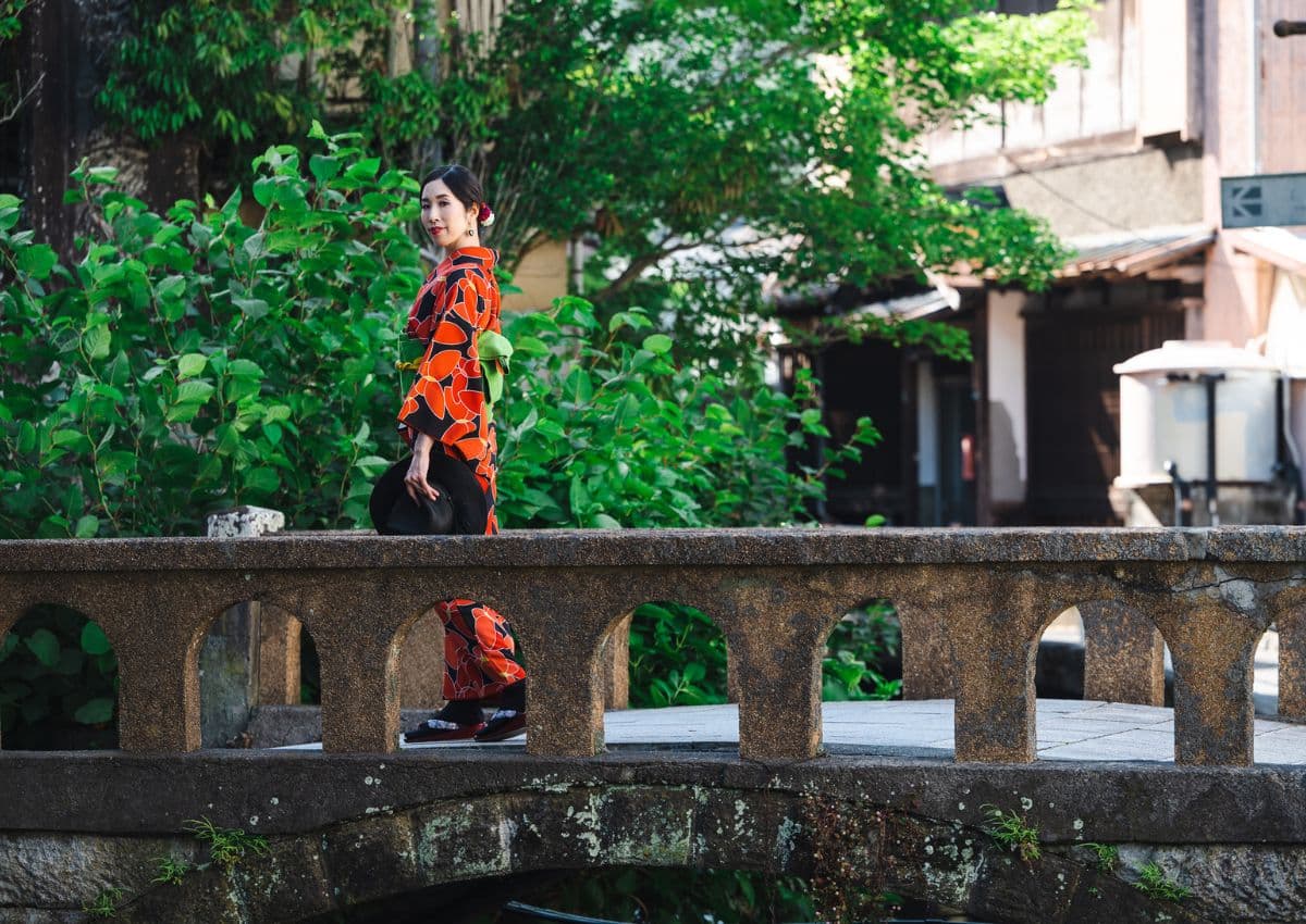 Femme en kimono traversant un pont dans la campagne japonaise