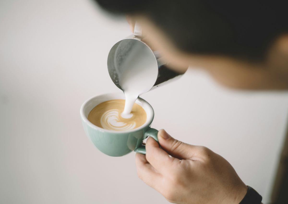 Lait moussant versé dans une tasse de cappuccino