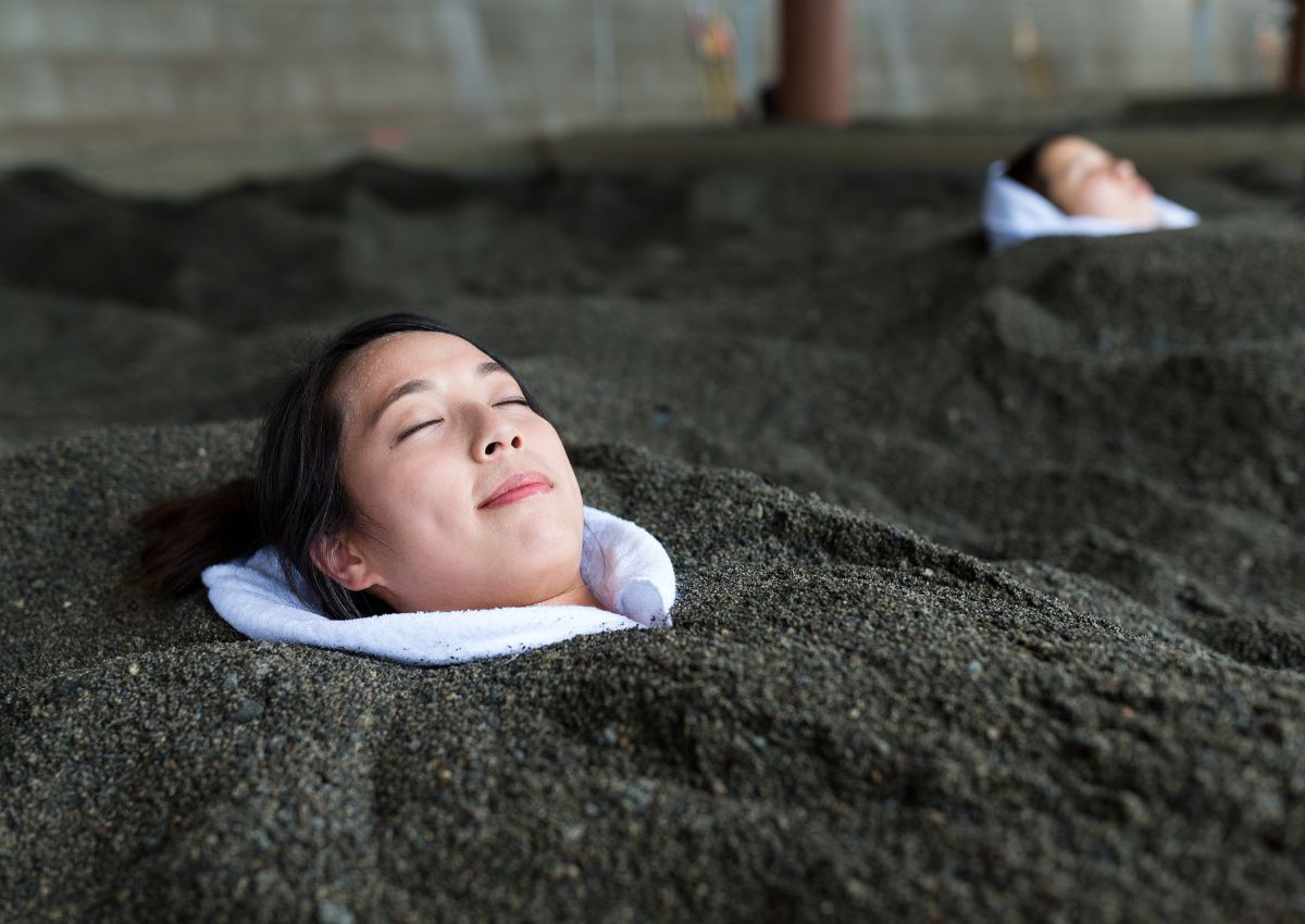 Femme profitant d'un bain de sable chaud, Kagoshima, Japon
