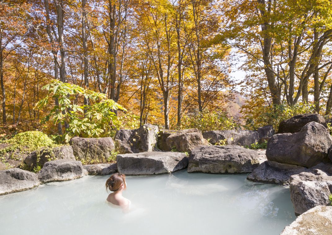 Source chaude en plein air au Japon dans un paysage d’automne