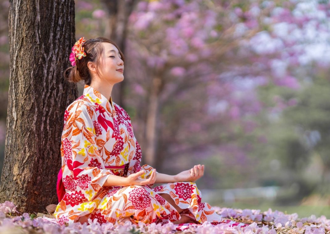Une femme japonaise pratique la méditation pendant la saison des cerisiers en fleurs pour retrouver la paix intérieure et la pleine conscience