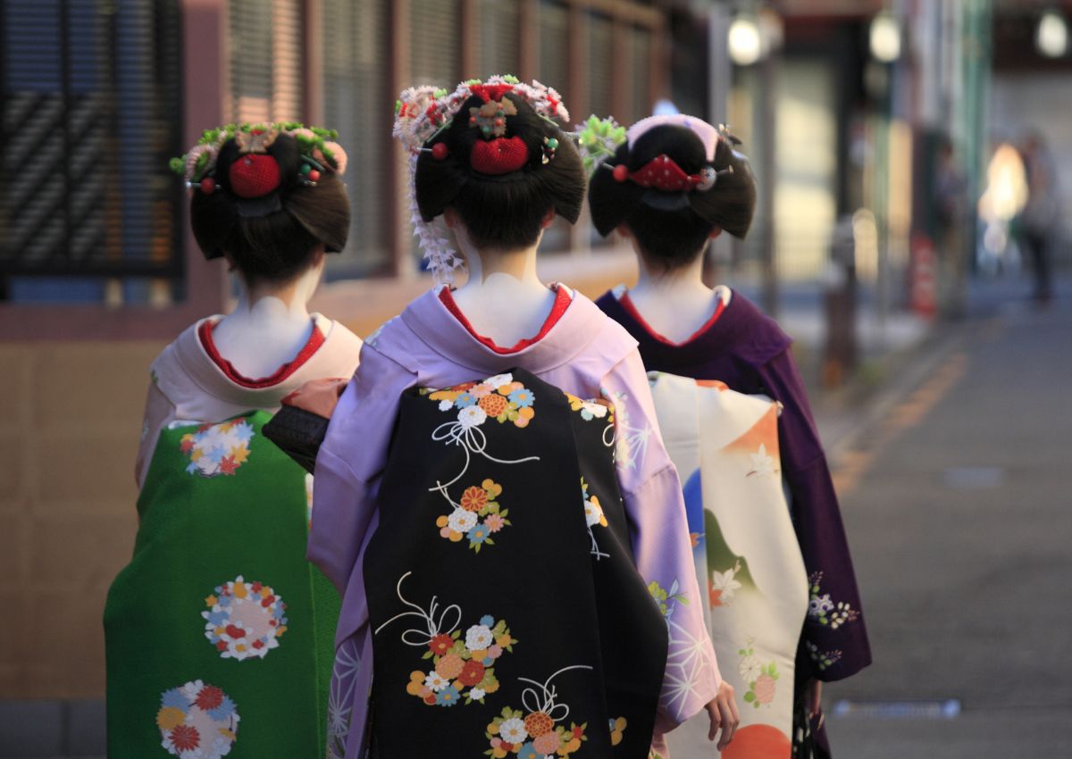 Trois geisha de dos dans la rue, Japon
