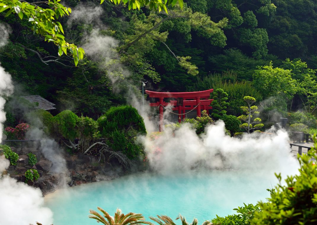 Source chaude aux eaux turquoise avec un torii rouge à Beppu, Japon