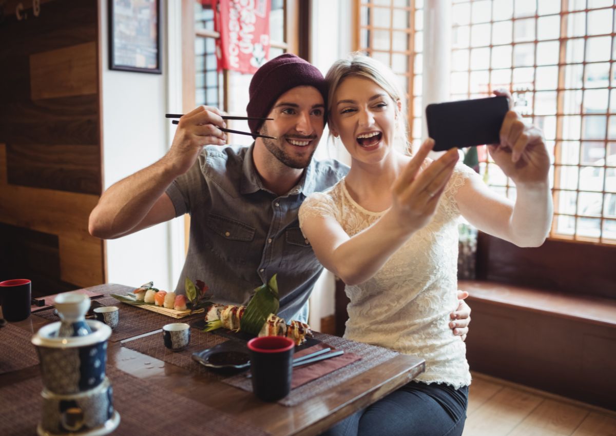 Couple se prenant en photo avec leur téléphone dans un restaurant au Japon