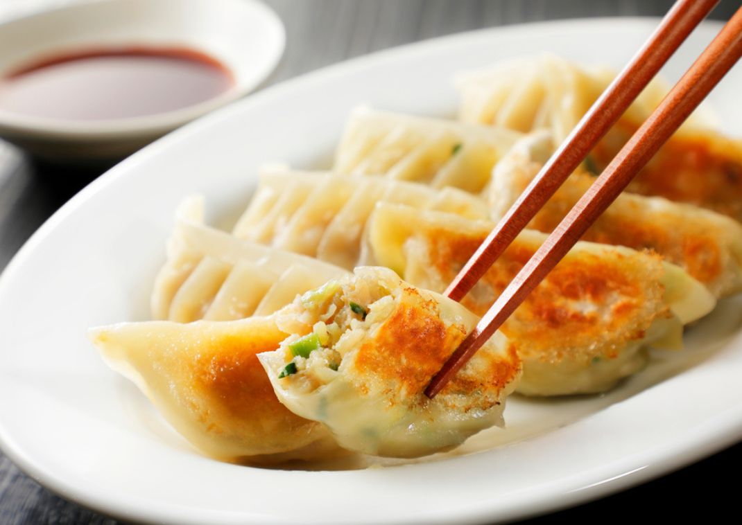 De délicieux gyoza grillés entre des baguettes