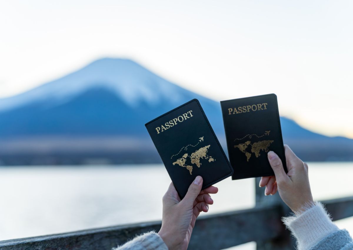 Mains de femmes tenant leur passeport devant le mont Fuji, Japon