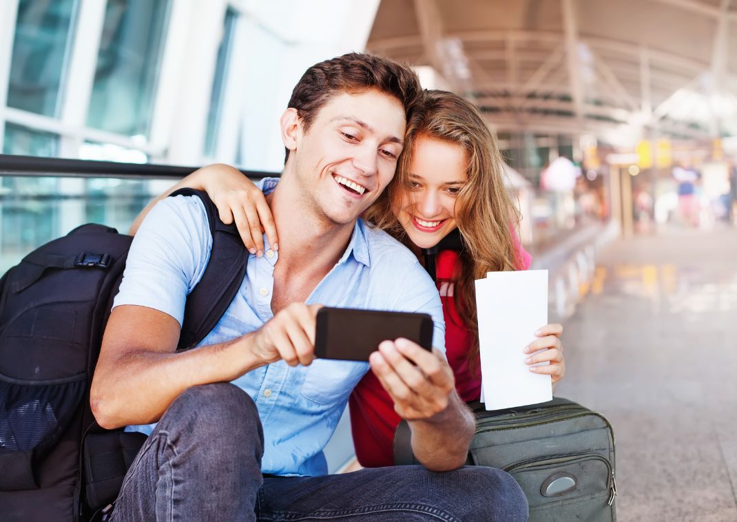 Couple regardant un téléphone dans un aéroport au Japon