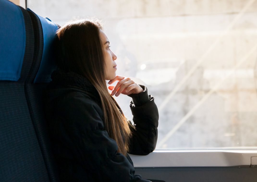 Jeune-femme-qui-regarde-par-la-fenêtre-dans-un-bus-pour-rejoindre-Tokyo 