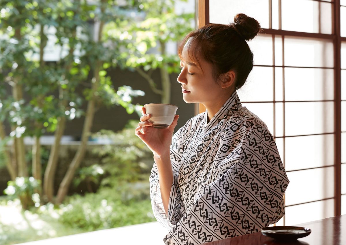 Jeune femme en yukata buvant du thé dans un ryokan, Japon
