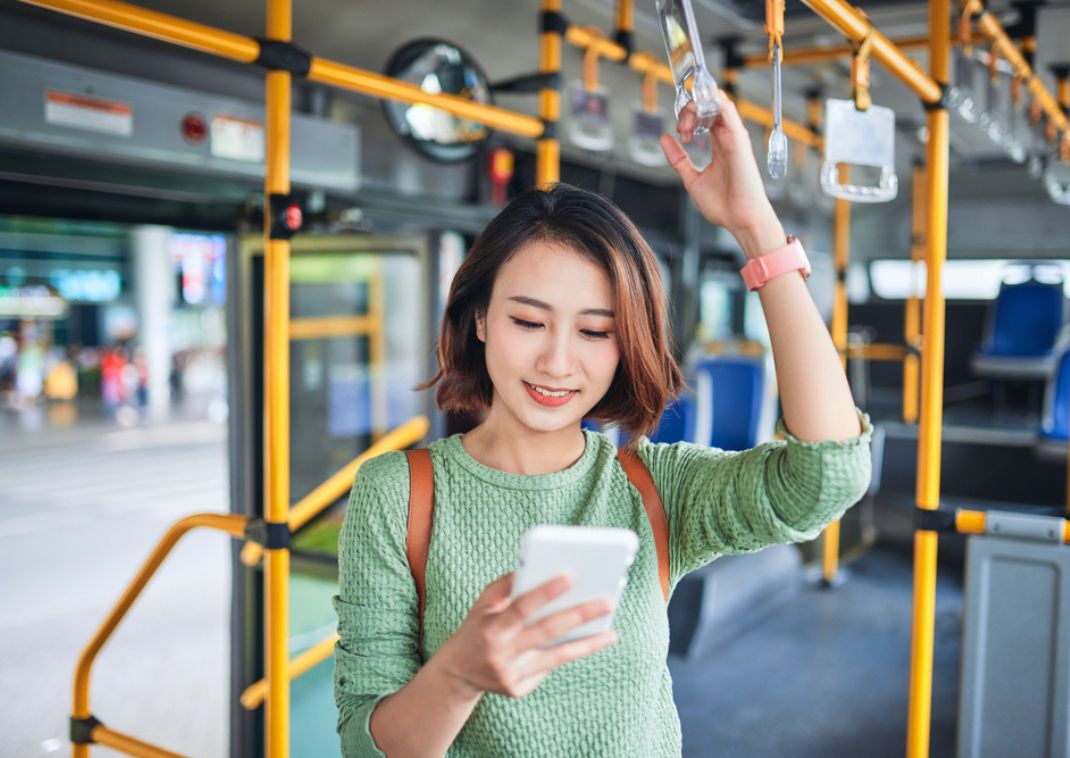 Jeune femme sur son téléphone dans un bus au Japon