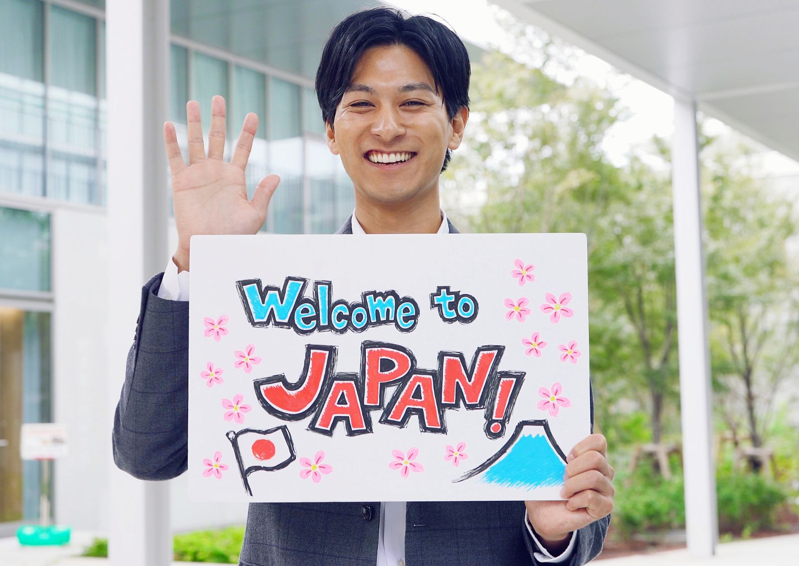  Jeune-homme-japonais-tenant-un-panneau-d-accueil-à-l-aéroport