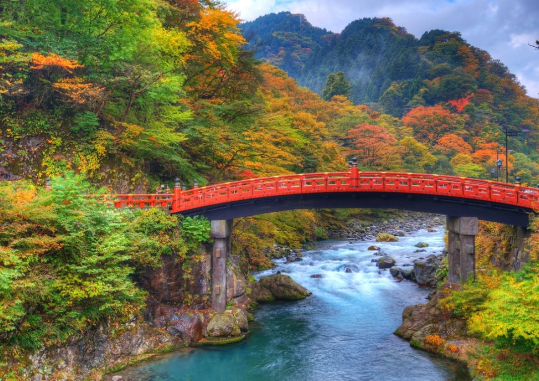 Pont rouge entouré de feuillage d’automne à Nikkō, Japon, en automne