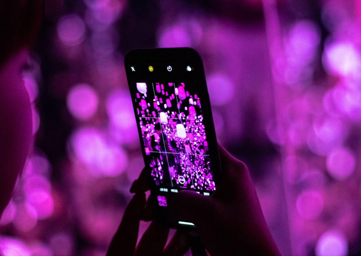 Visiteuse prenant une photo d’une installation lumineuse du teamLab, Tokyo, Japon