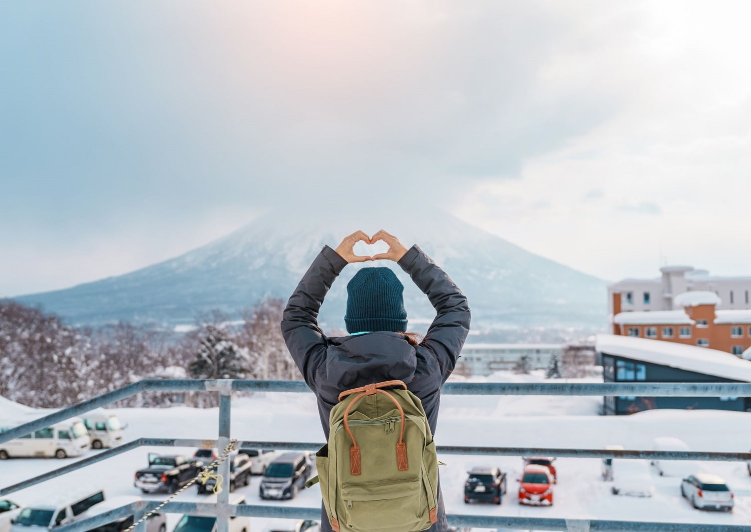 Femme de dos formant un cœur avec les mains au-dessus de sa tête à Niseko, Hokkaido, Japon
