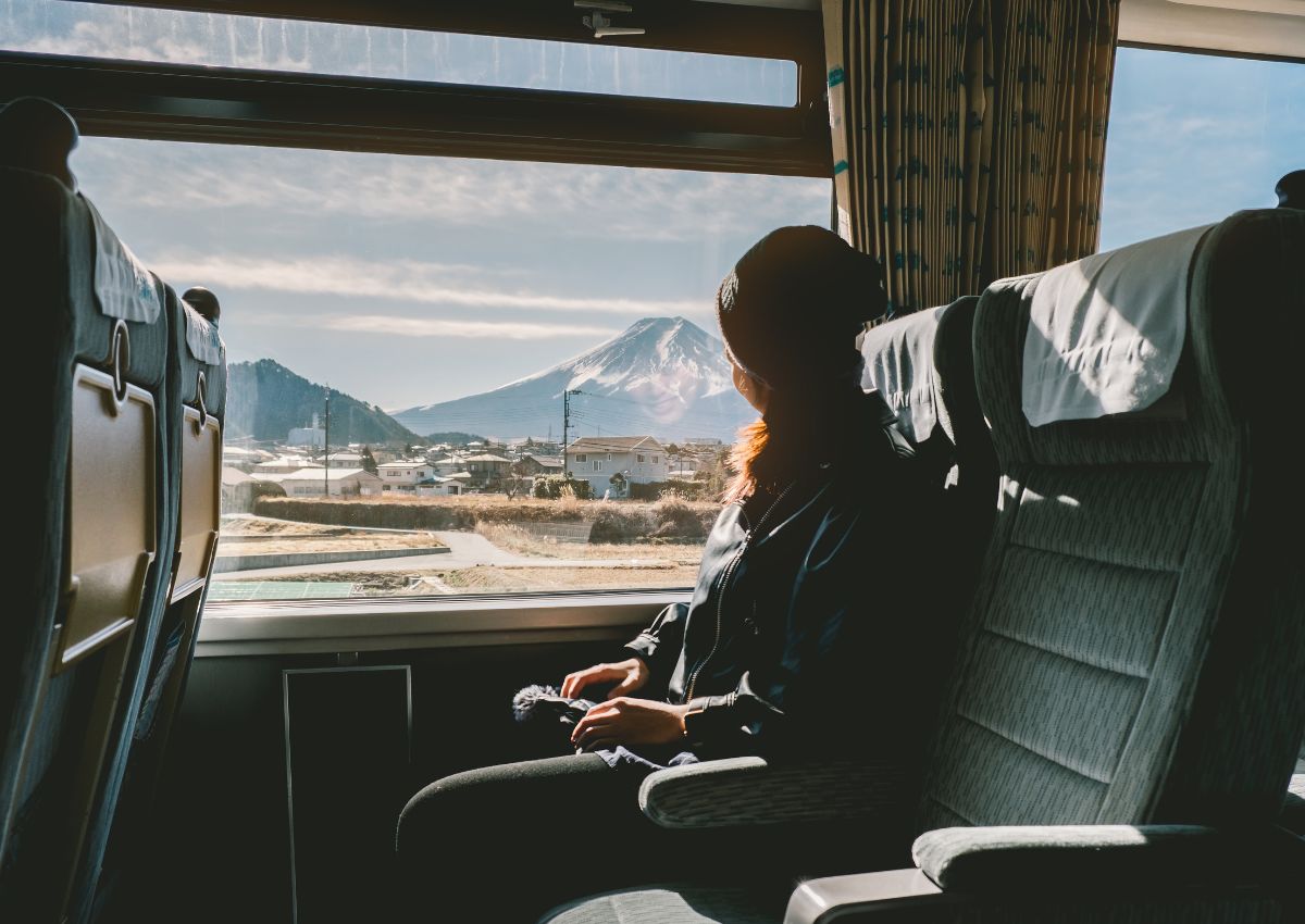 Femme voyageant en train côté fenêtre avec vue sur le Mont Fuji.