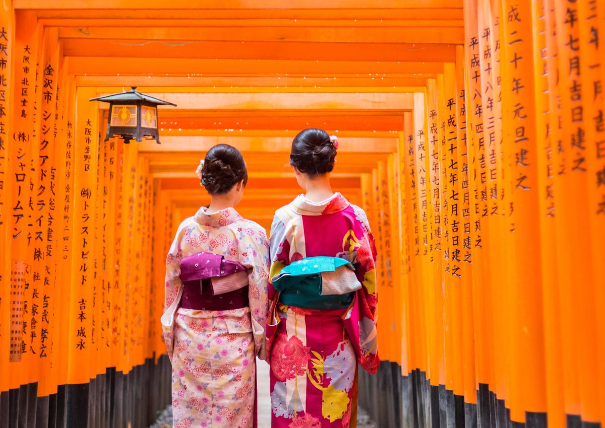 Deux femmes en kimono remontant le tunnel de torii orange du sanctuaire Fushimi Inari à Kyoto, Japon