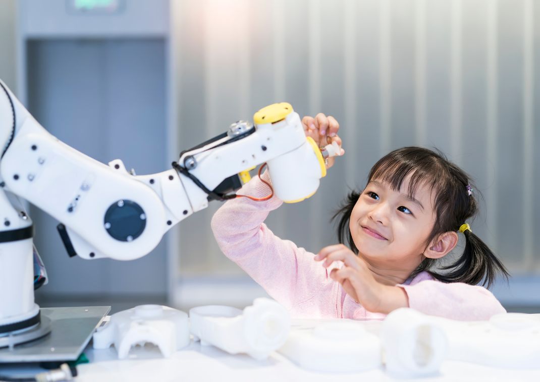 Petite fille jouant avec un bras robotisé, Japon