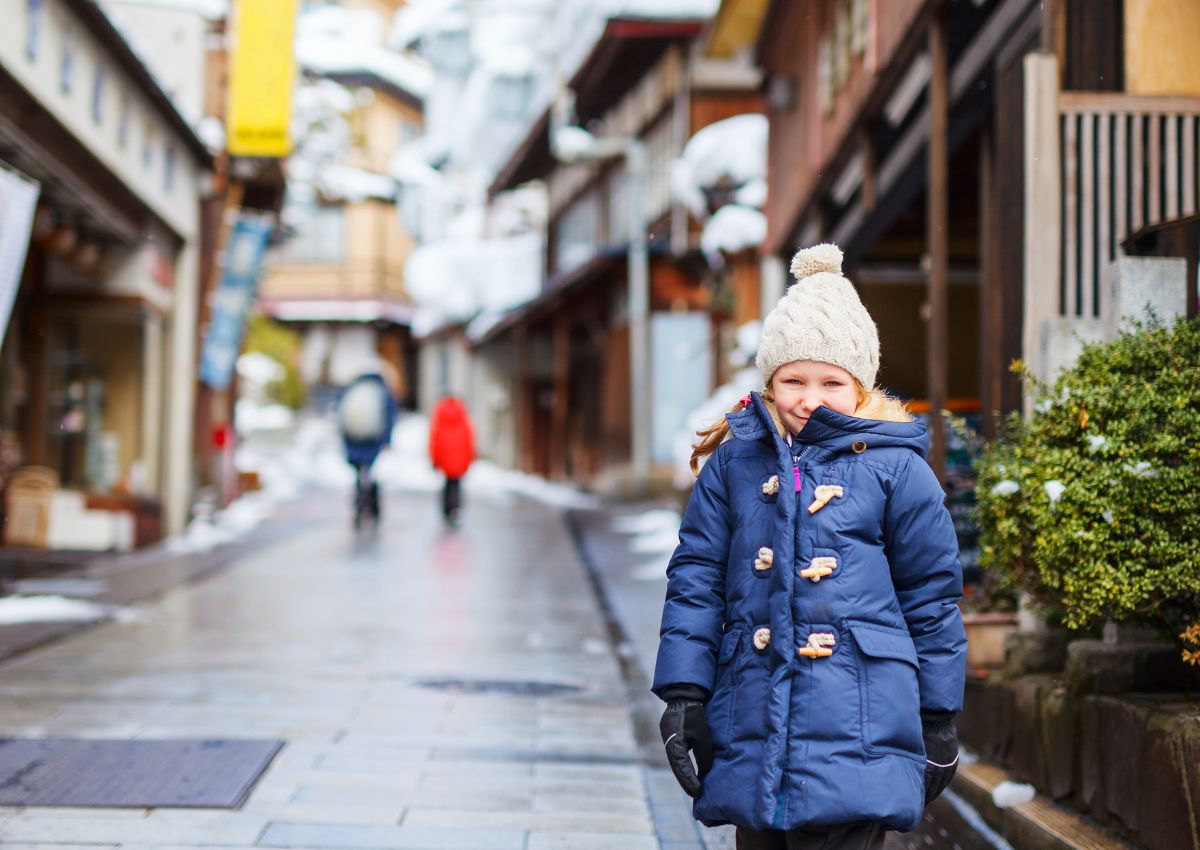Petite fille dans les rues d'une ville thermale enneigée du Japon