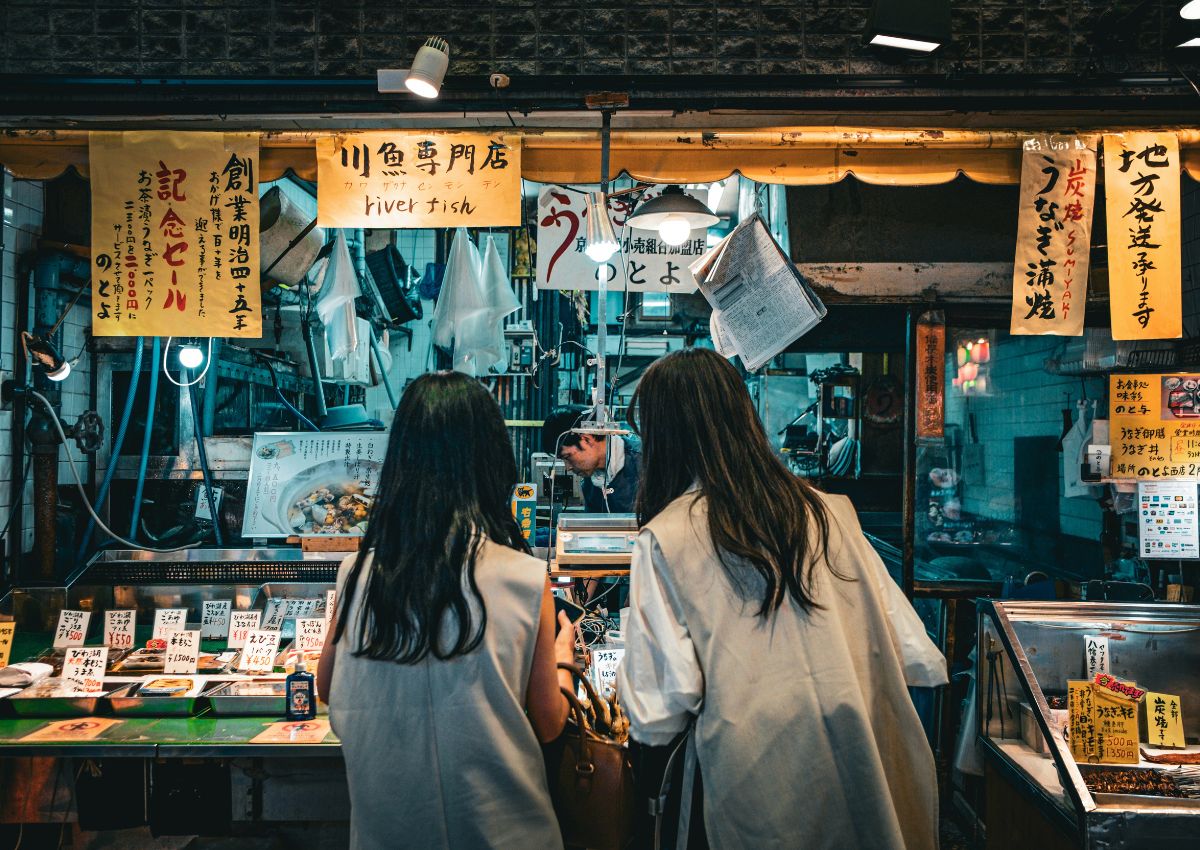 Deux touristes observant les produits du marché Nishiki, Kyoto, Japon