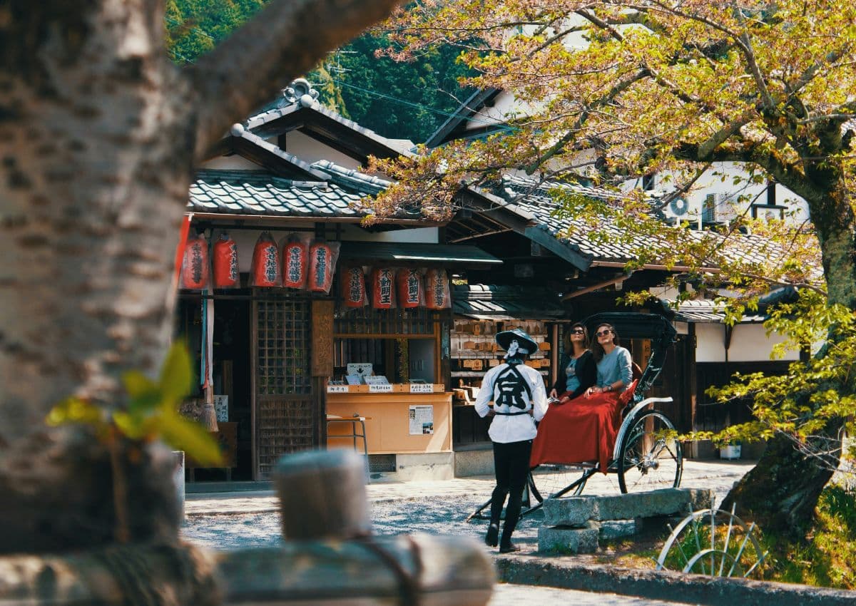 Deux touristes à bord d'un pousse-pousse japonais à Kyoto