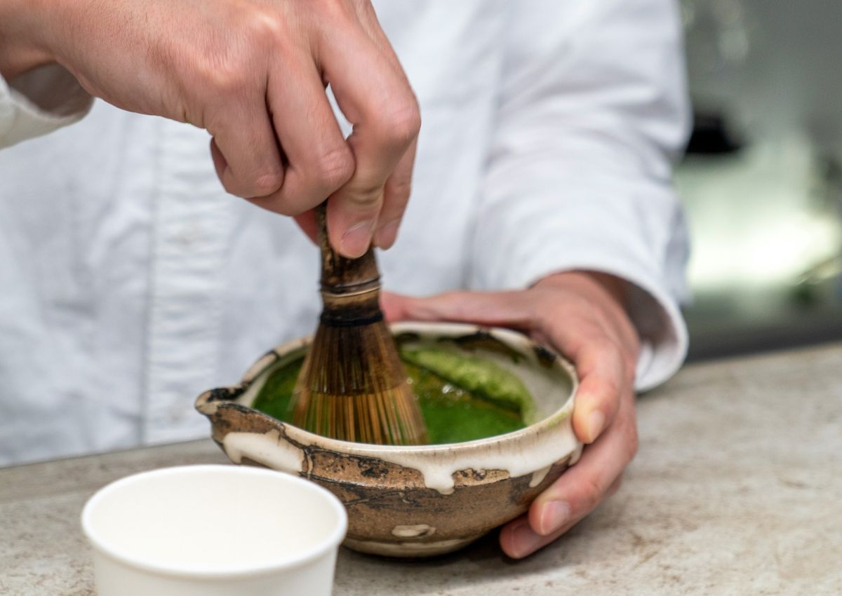 Serveur préparant le matcha avec un fouet, Japon