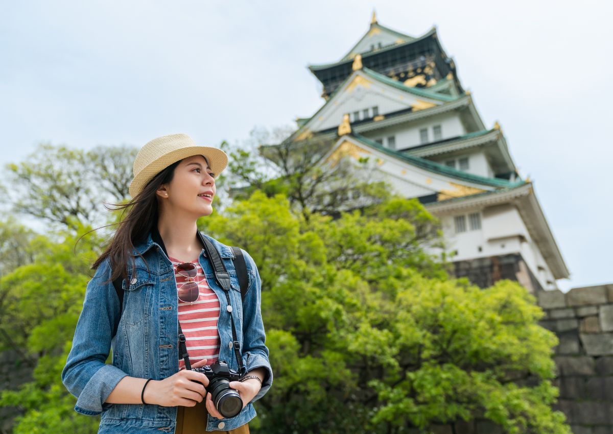 Touriste tenant un appareil photo au pied du château d’Osaka, Japon