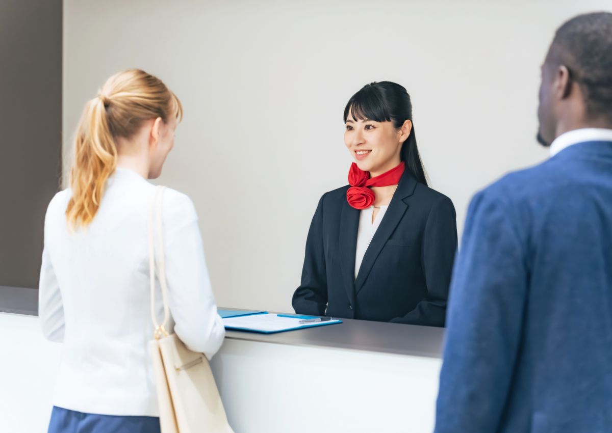 Touristes se présentant à la réception d’un hôtel japonais