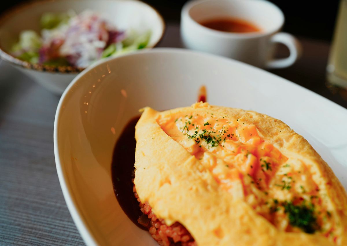 Omurice accompagné d’une boisson sur une table en bois