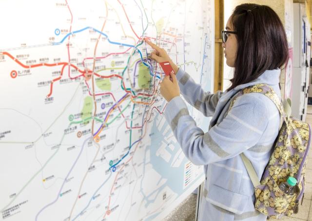 Voyageuse souriante tenant une carte papier pour se repérer à Tokyo, Japon