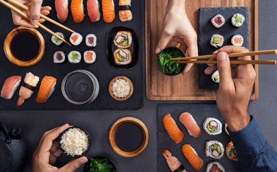 Sushis assortis (nigiri, sashimi et rouleaux) partagés et dégustés à l'aide de baguettes.
