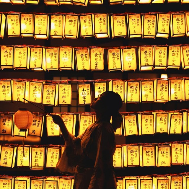 Personne avec une lanterne devant des lanternes de festival japonaises illuminées