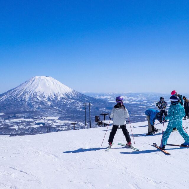 Skieurs en haut des pistes face à un volcan, Hokkaido, Japon