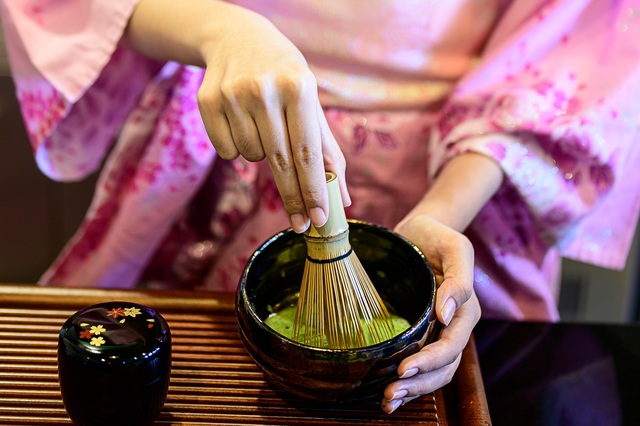 Femme en kimono préparant du thé vert japonais