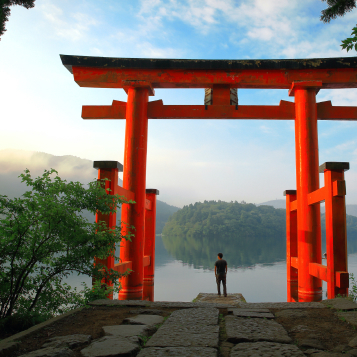 Touriste à la porte torii rouge du sanctuaire de Hakone, situé sur le lac Ashi, Japon