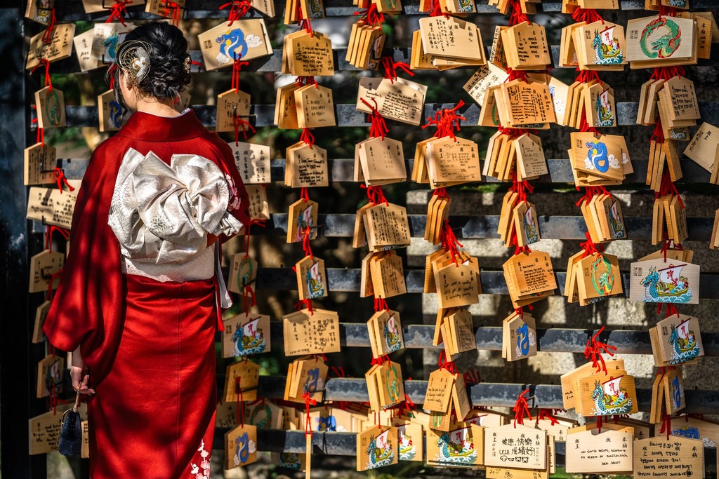Femme japonaise lisant des cartes de prière sur un tableau en bois au temple Kiyomizu-dera à Kyoto