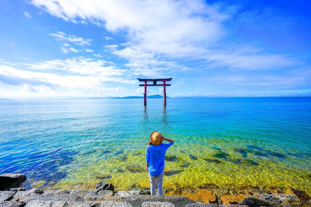 Voyageur près d'une porte torii au lac Biwa dans la préfecture de Shiga, au Japon.