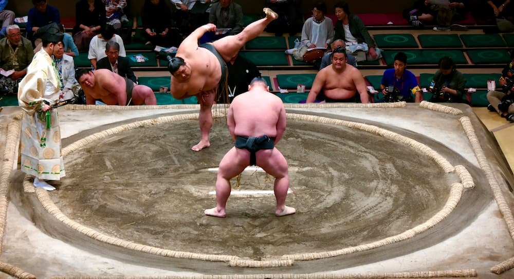Lutteurs japonais de sumo se préparant à un match sur le ring, vêtus du traditionnel mawashi