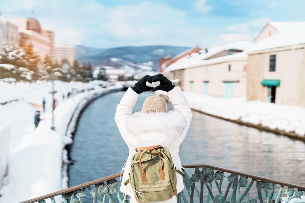 Touriste faisant du tourisme le long du canal enneigé d'Otaru à Hokkaido, au Japon, profitant de la saison hivernale.
