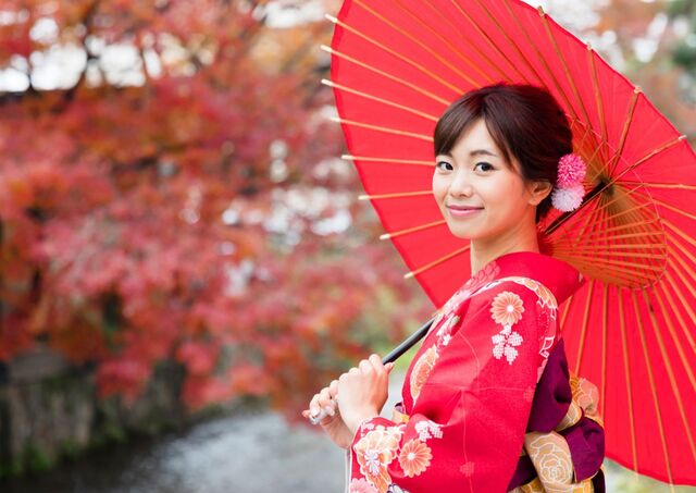 Jeune femme en kimono portant une ombrelle japonaise durant l’automne au Japon