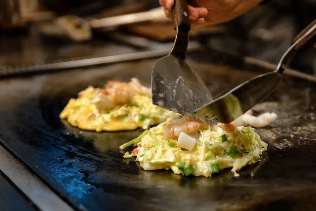 Cuisson d'un okonomiyaki sur une plaque chauffante