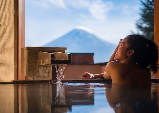 Jeune femme dans un bain chaud devant le mont Fuji, Japon